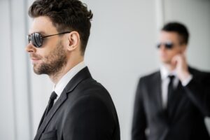 surveillance, bodyguard in sunglasses and black suit with tie, hotel safety, security management,